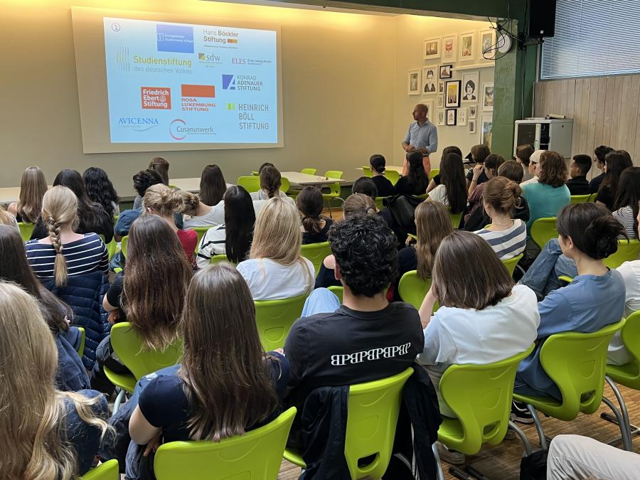 Schüler hören sich in der Schulmensa einen Vortrag zu vielfältigen beruflichen Möglichkeiten an 